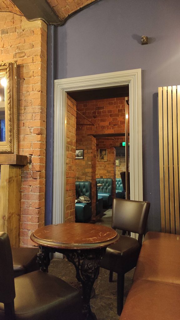 5 Pubs À Ne Pas Manquer Lors De Votre Prochaine Visite À Liverpool 12 Intérieur de pub avec table en bois