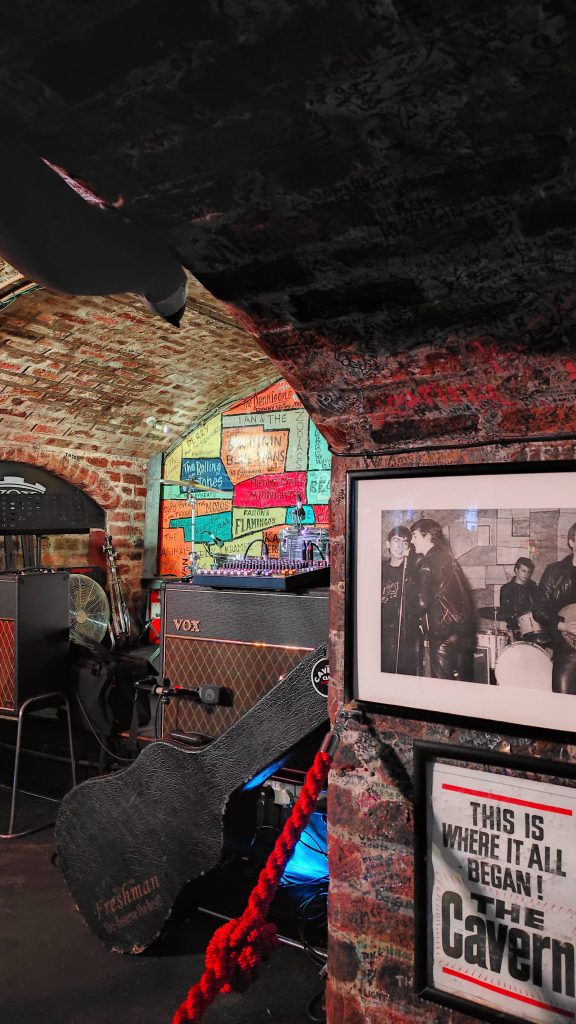 5 Pubs À Ne Pas Manquer Lors De Votre Prochaine Visite À Liverpool 2 Scène avec amplificateurs de guitares et guitares, dans un sous-sol en briques du Cavern Club
