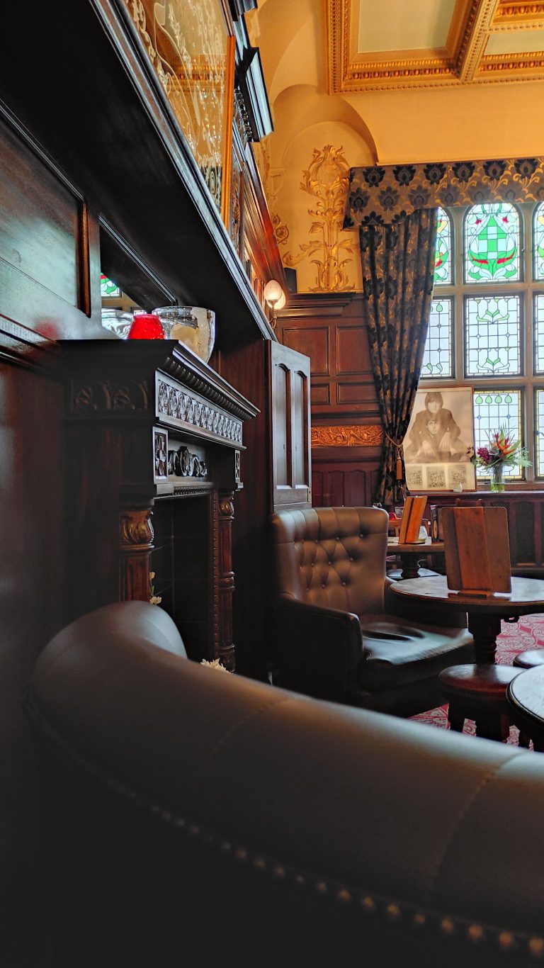 fauteuils en cuir devant une cheminée avec des tables dans un pub anglais