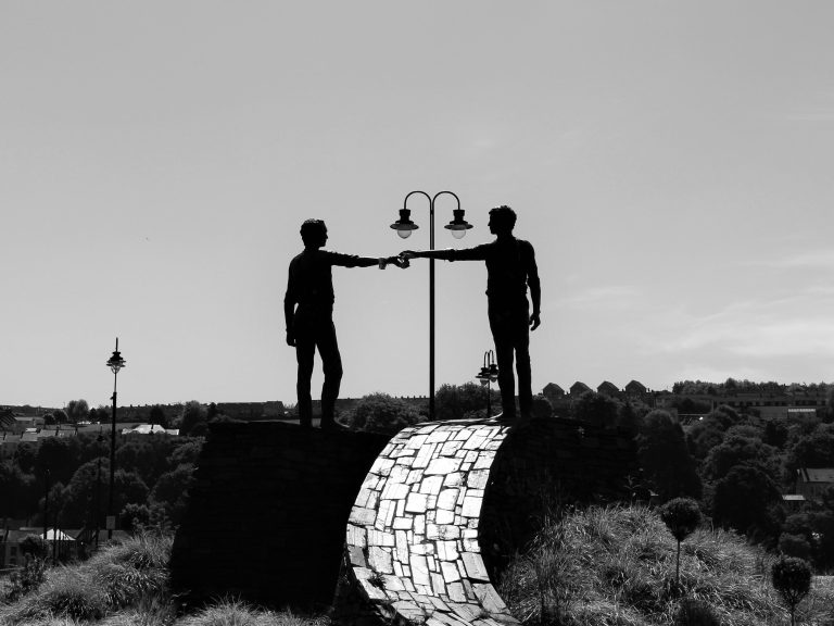 statue de deux hommes tendant la main l'un vers l'autre à belfast lors d'un road trip en irlande du nord