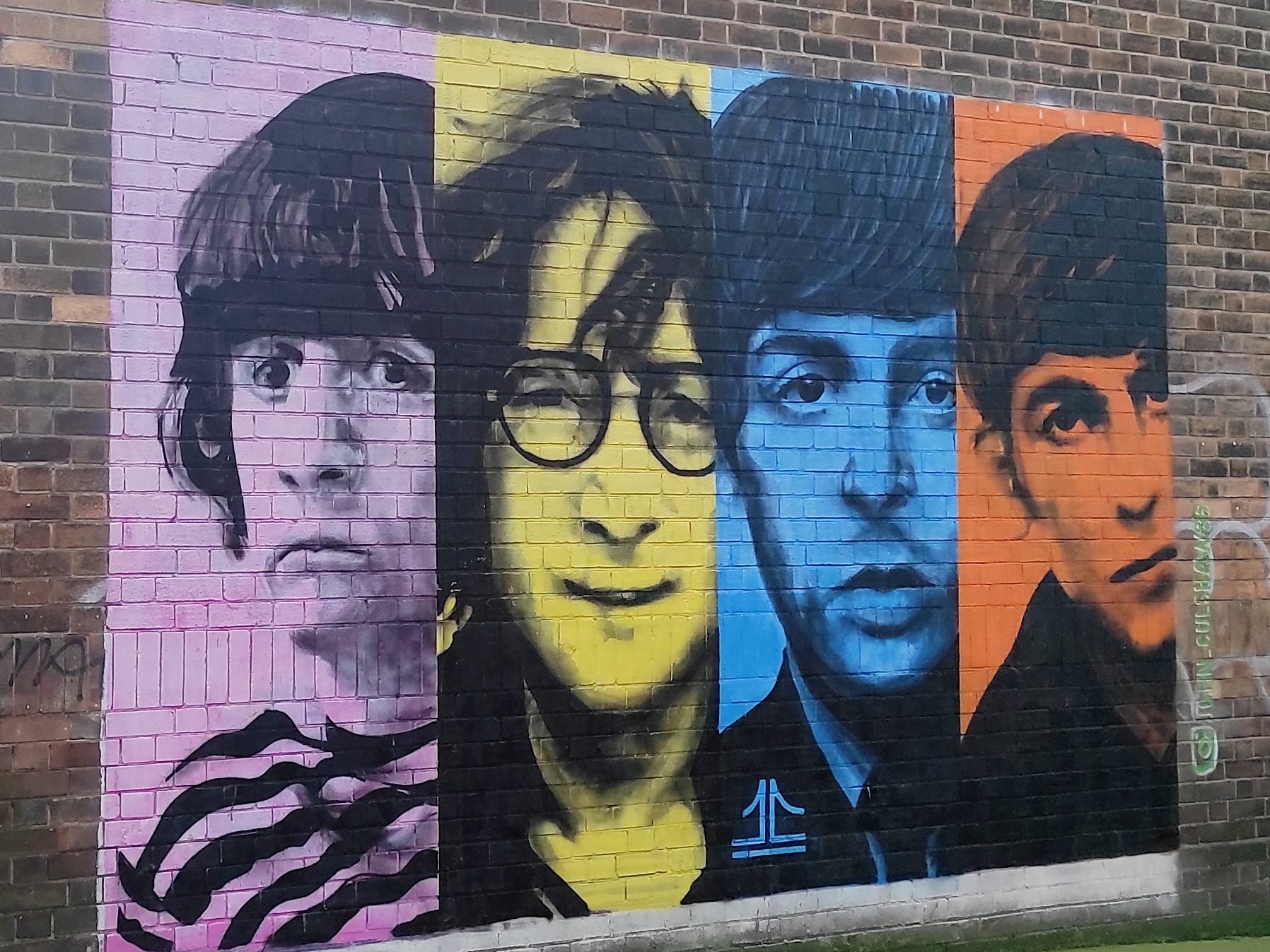 Liverpool et les Beatles : musées, visites, et lieux emblématiques à ne pas manquer 13 Street art représentant les Beatles sur un mur en briques