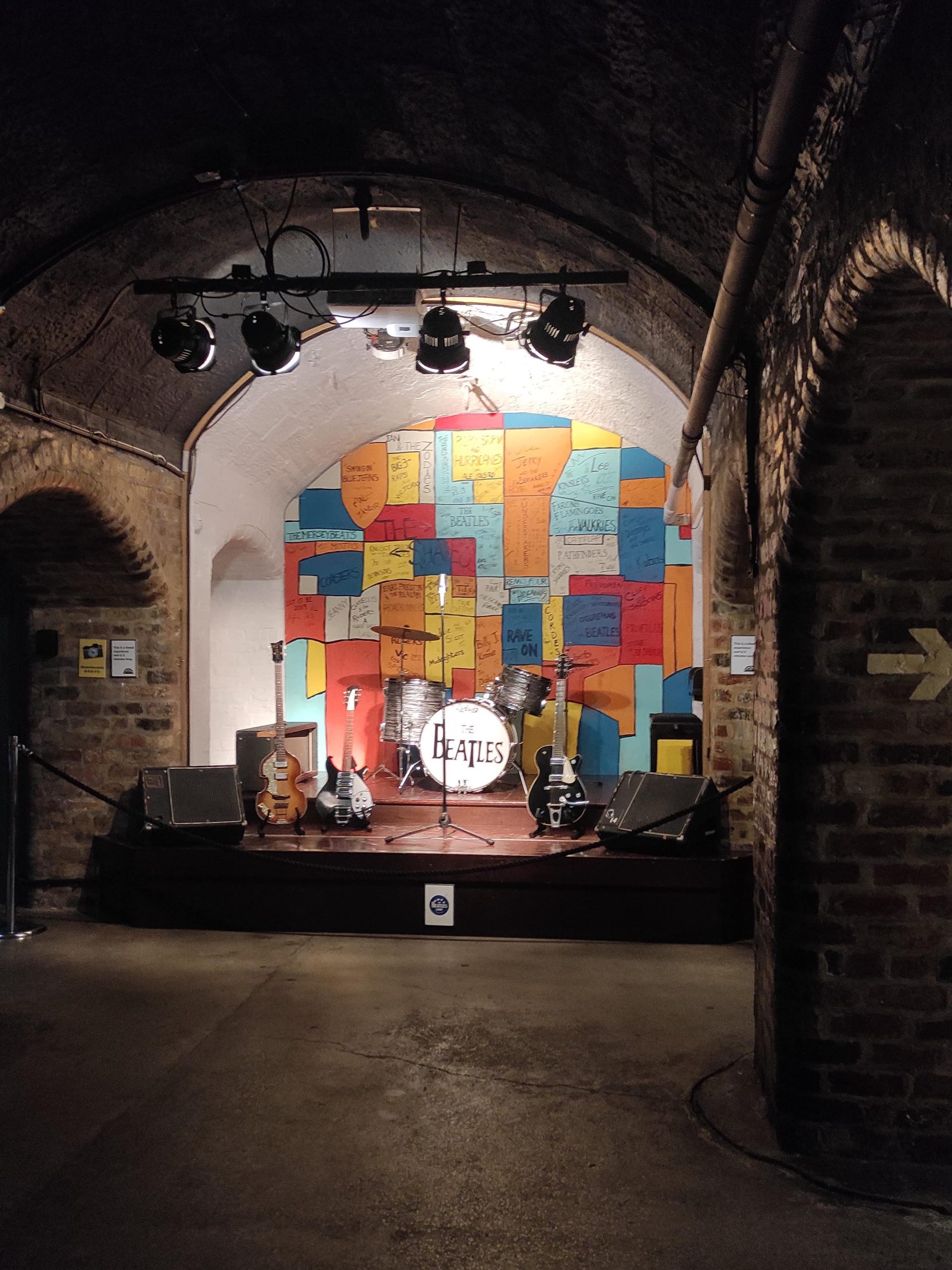 Liverpool et les Beatles : musées, visites, et lieux emblématiques à ne pas manquer 8 L'histoire de Liverpool et les Beatles est présentée au musée the Beatles Story. Les photos représentent différentes scènes et objets de leur parcours : les instruments utilisés sur certaines chansons en studio (basse, guitares et batterie), scène du club cavern, extrait de presse encadré au mur.
