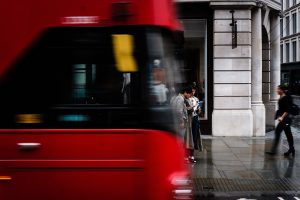 avant de bus rouge anglais au premier plan avec rue de londres en arrière plan avec des gens des marchent sur le trottoir