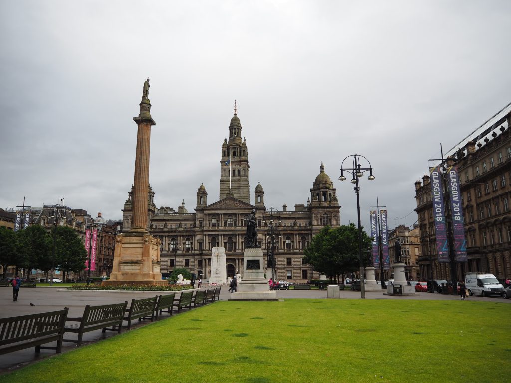 3 circuits parfaits pour visiter Glasgow le temps d'un long weekend 15 Vue sur un parc avec au premier plan une pelouse, au milieu des statues avec notamment une colonne grecque, et dans le fond un grand bâtiment en pierre claire.