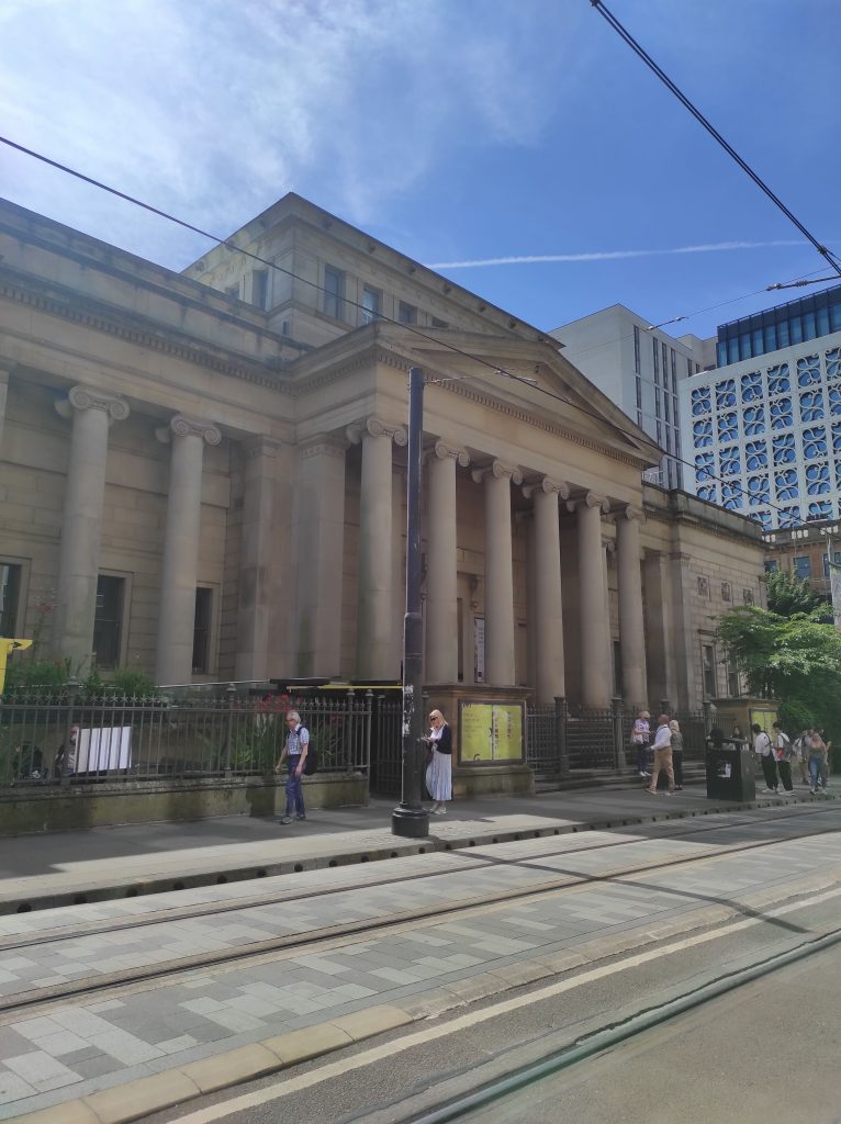 4 musées à Manchester à découvrir absolument sans débourser un centime 6 Entrée de la Manchester Art Gallery avec ligne de tram au premier plan et bâtiment à colonnes en pierre grise au second plan