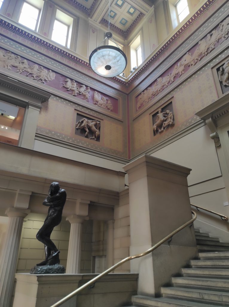 4 musées à Manchester à découvrir absolument sans débourser un centime 7 Hall d'entrée de la Manchester Art Gallery avec statue puis escalier qui tourne, grande hauteur sous plafond, lustre.