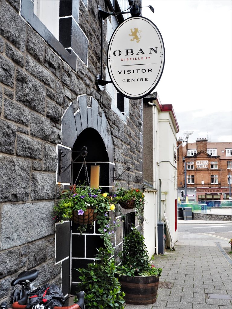 Visiter une Distillerie en Écosse : Tout Ce Qu’il Faut Savoir 3 Enseigne extérieure de la distillerie d'Oban. Bâtiment en pierres grises